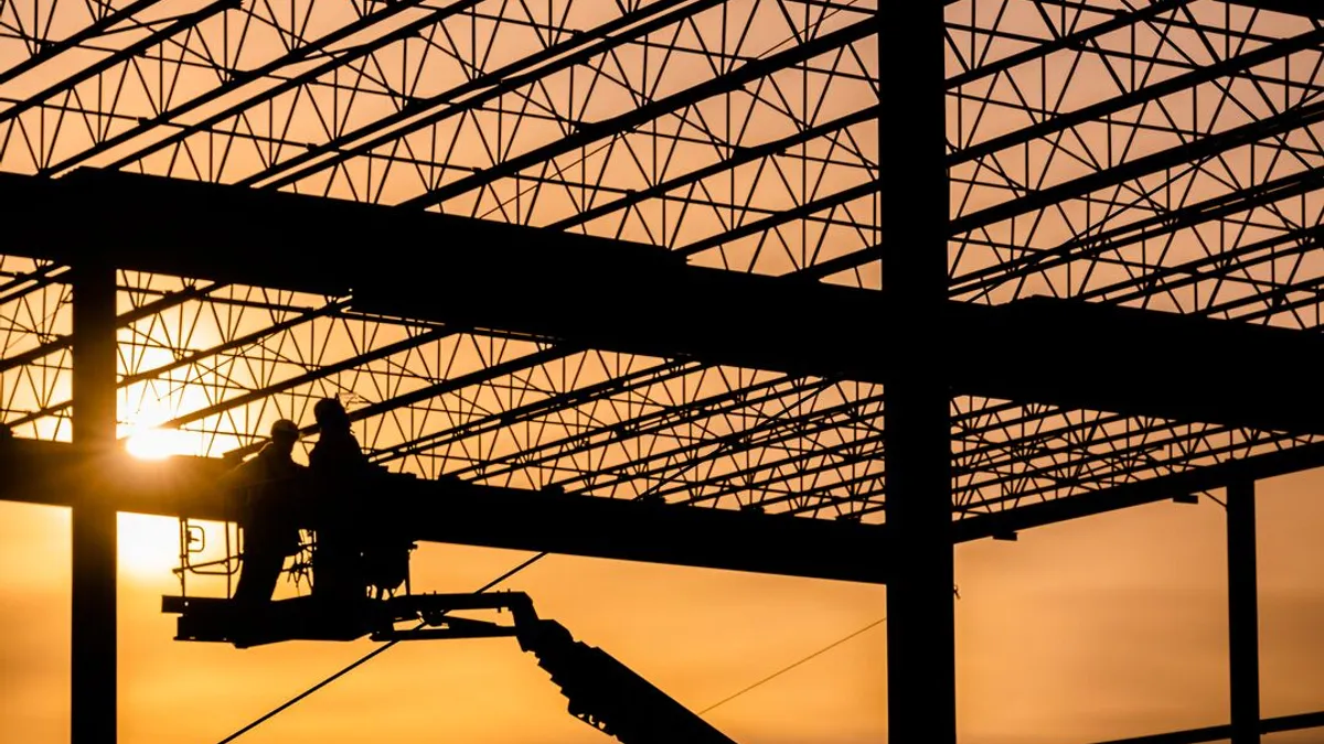 A warehouse rises from a construction site