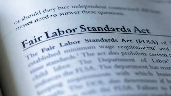 An open textbook displays the Fair Labor Standards Act's title in bold type