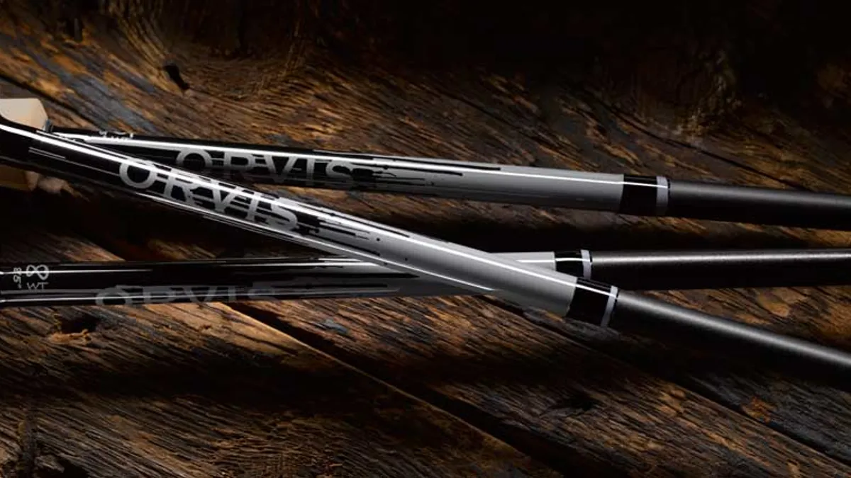 three Orvis-branded fly fishing rods against a wood background