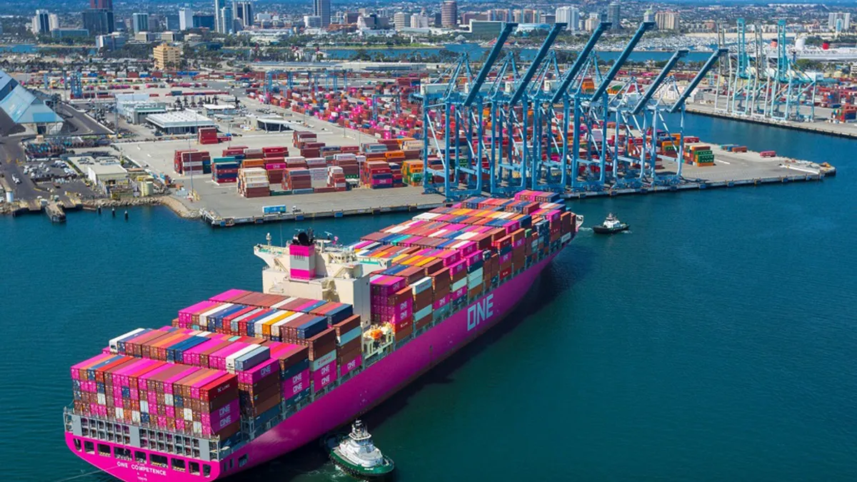 A containership being moved by tugs boats to berth at a port.