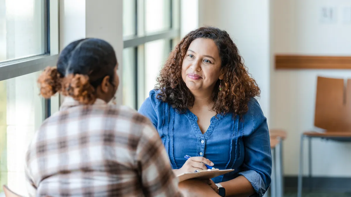 Two women sitting on a table and chatting