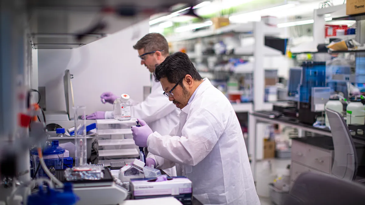 Biogen employees at a lab bench conducting research on movement disorders