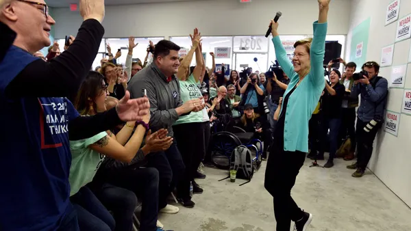 woman raising her hands in front of a crowd