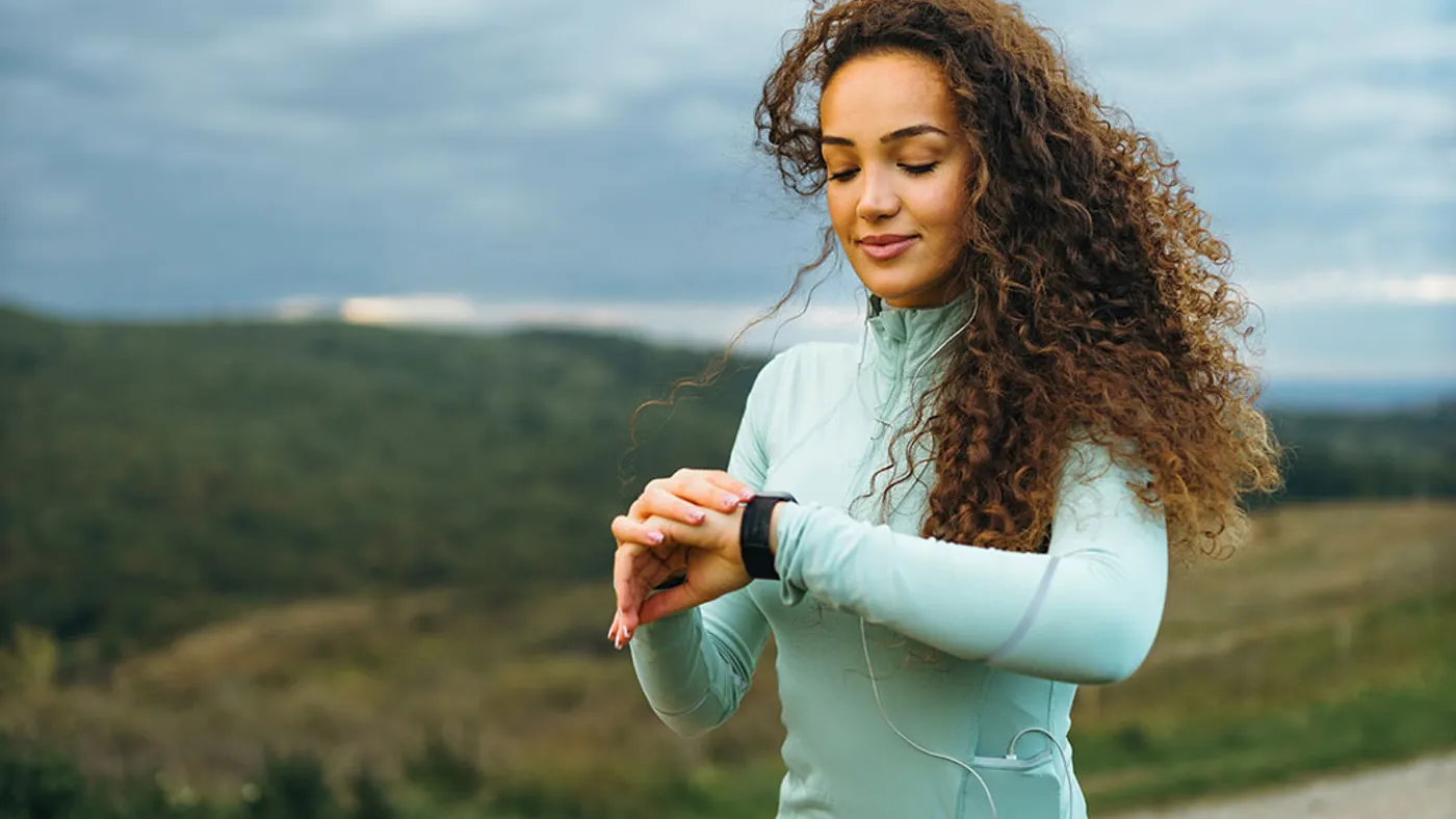 A fitness girl is looking at her smart watch