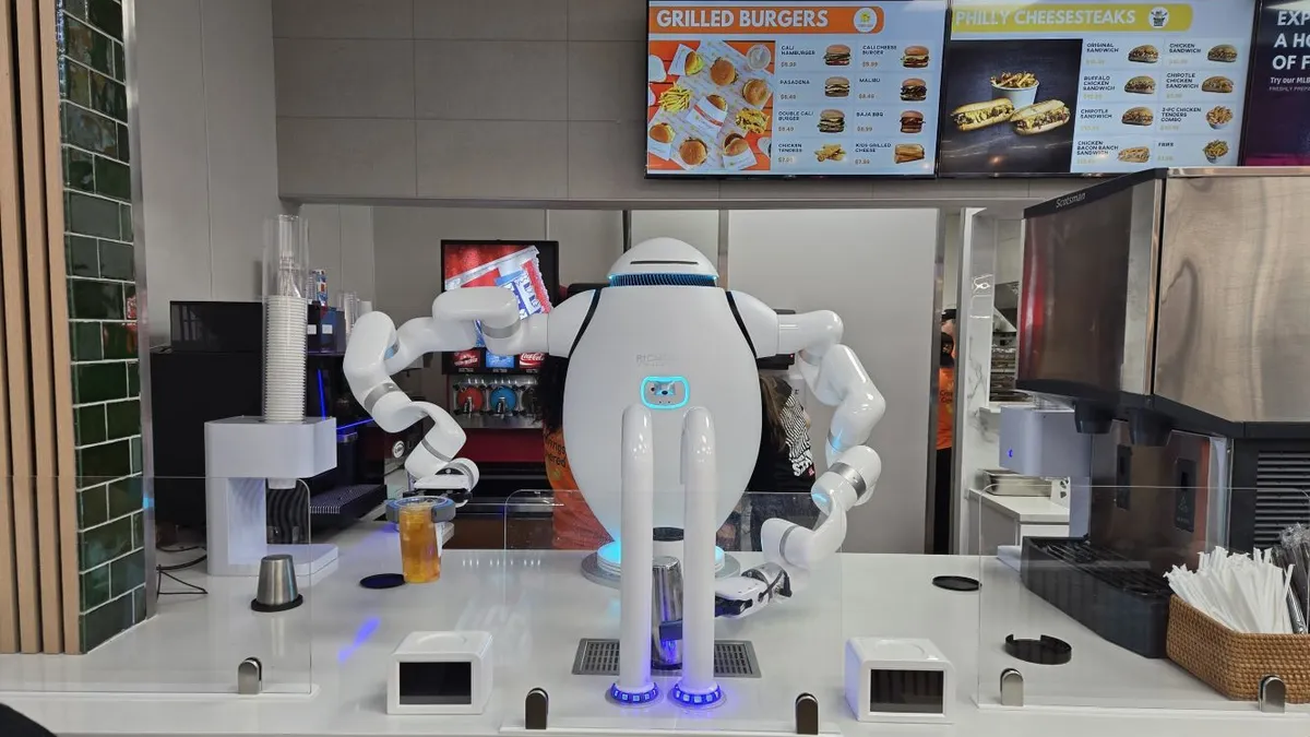 An image of a Richtech Robotics adanced robotic beverage system. The white robot is preparing a drink at a counter top.