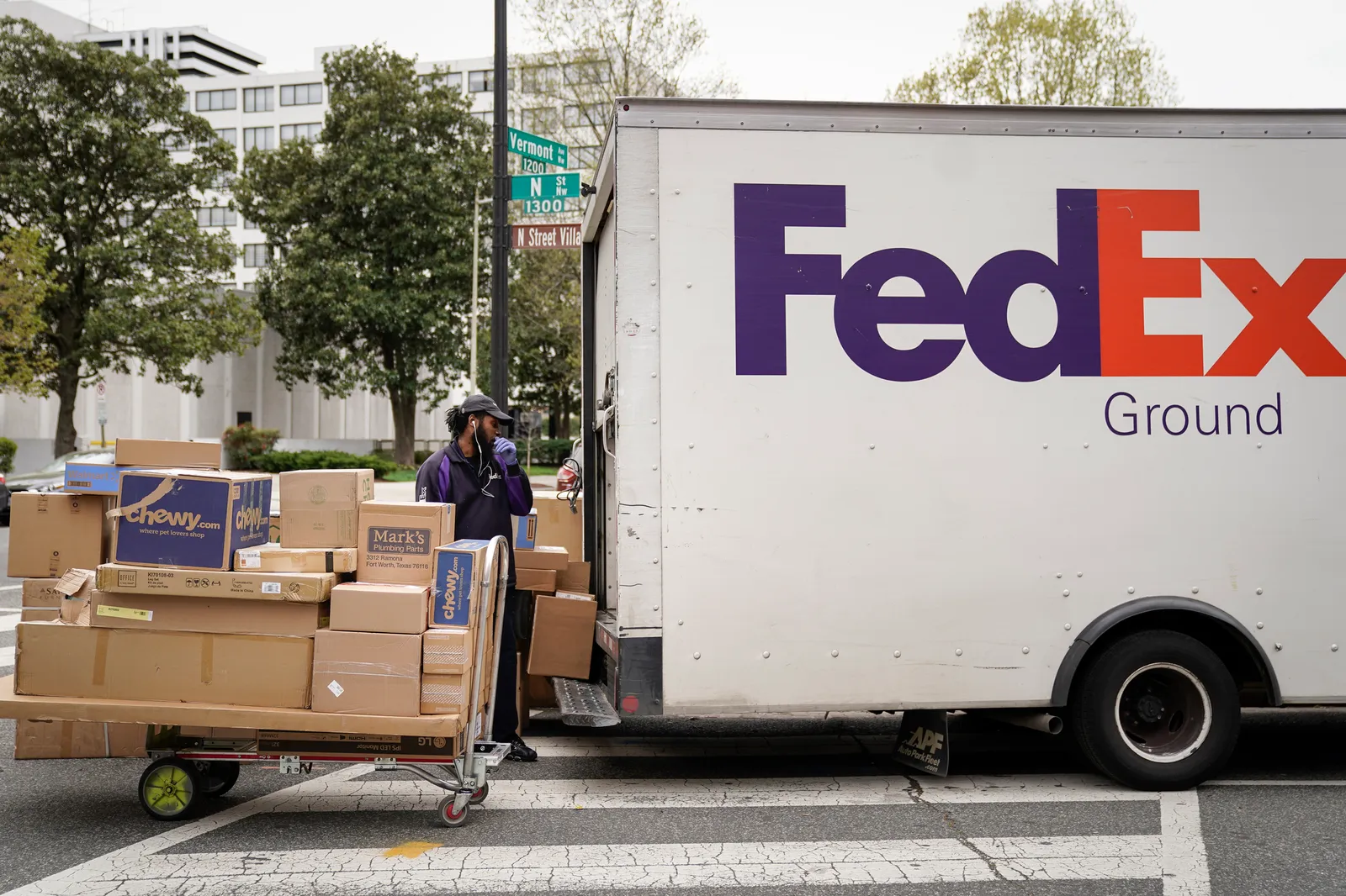 A FedEx worker unloads packages from his delivery truck on March 31, 2020 in Washington D.C.