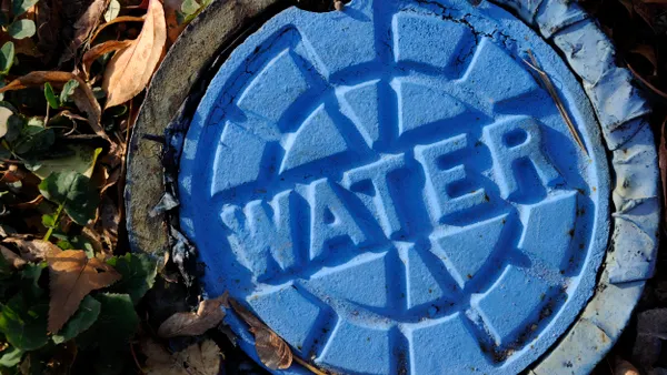A round blue metal lid with the word WATER written on it.