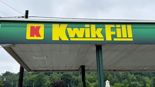 A photo of a fuel canopy. The canopy is green and has the words Kwik Fill, along with the company logo, in yellow and red.