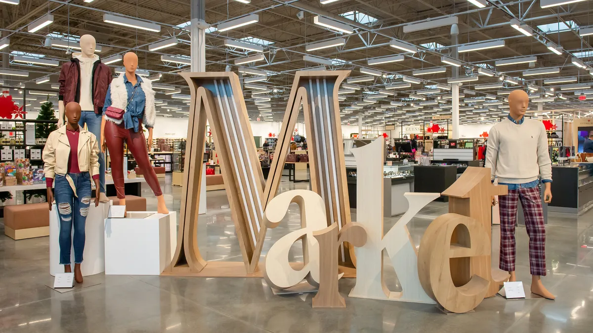 Mannequins flank large wooden letters spelling out the word "market."