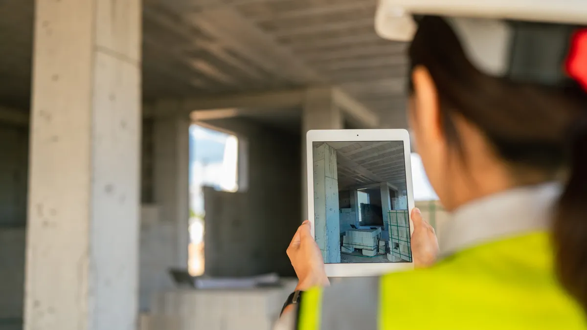 A female engineer is using a digital tablet on a construction site.