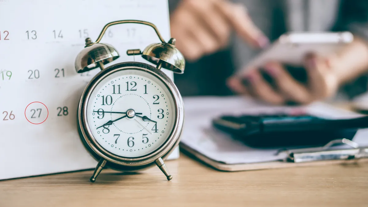 Image of calendar with a clock next to it.