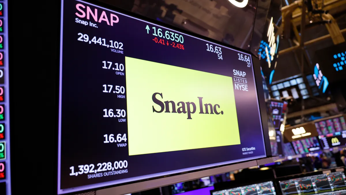 A screen on the floor of the New York Stock Exchange shows Snap's logo and stock information.