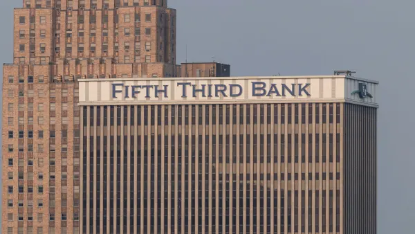 High-rise building with the sign 'Fifth Third Bank' at the top, located in a cityscape with another brick skyscraper in the background.