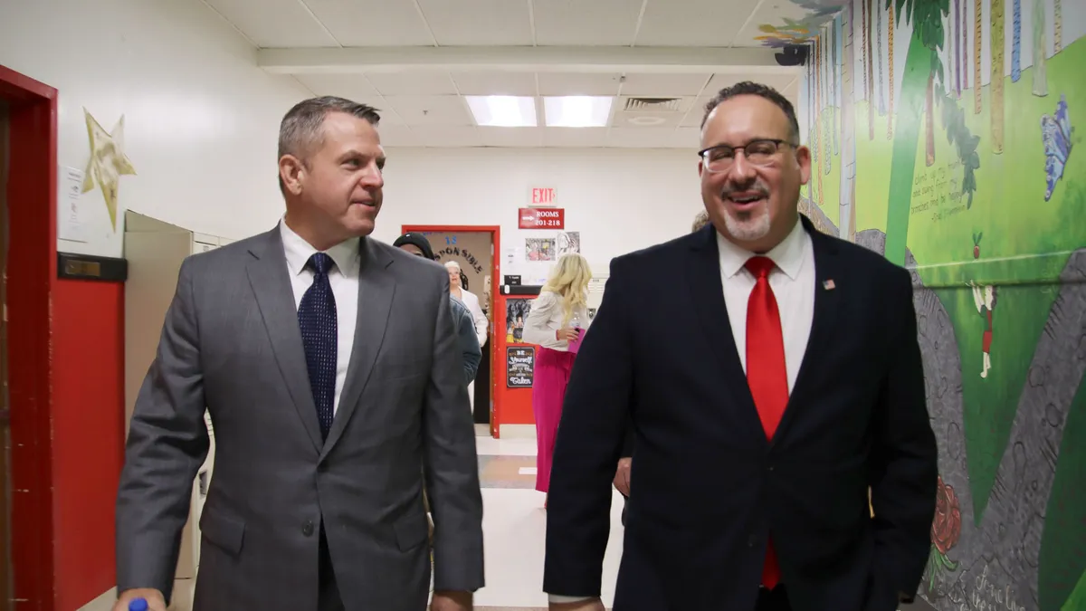 U.S. Department of Education Miguel Cardona and former Kentucky Commissioner of Education Jason E. Glass walk side by side