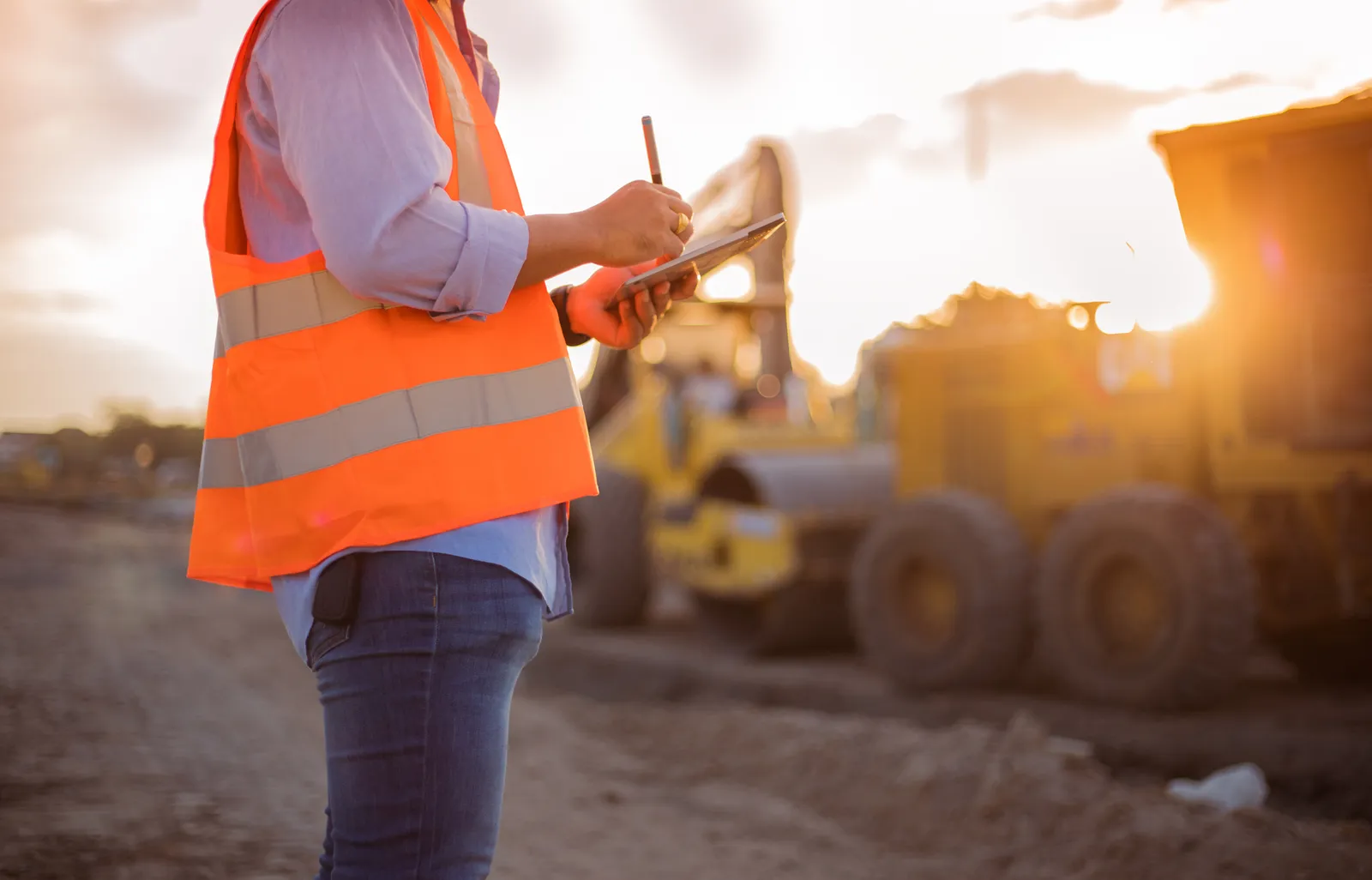 engineer with hardhat using tablet pc computer inspecting and working at construction site