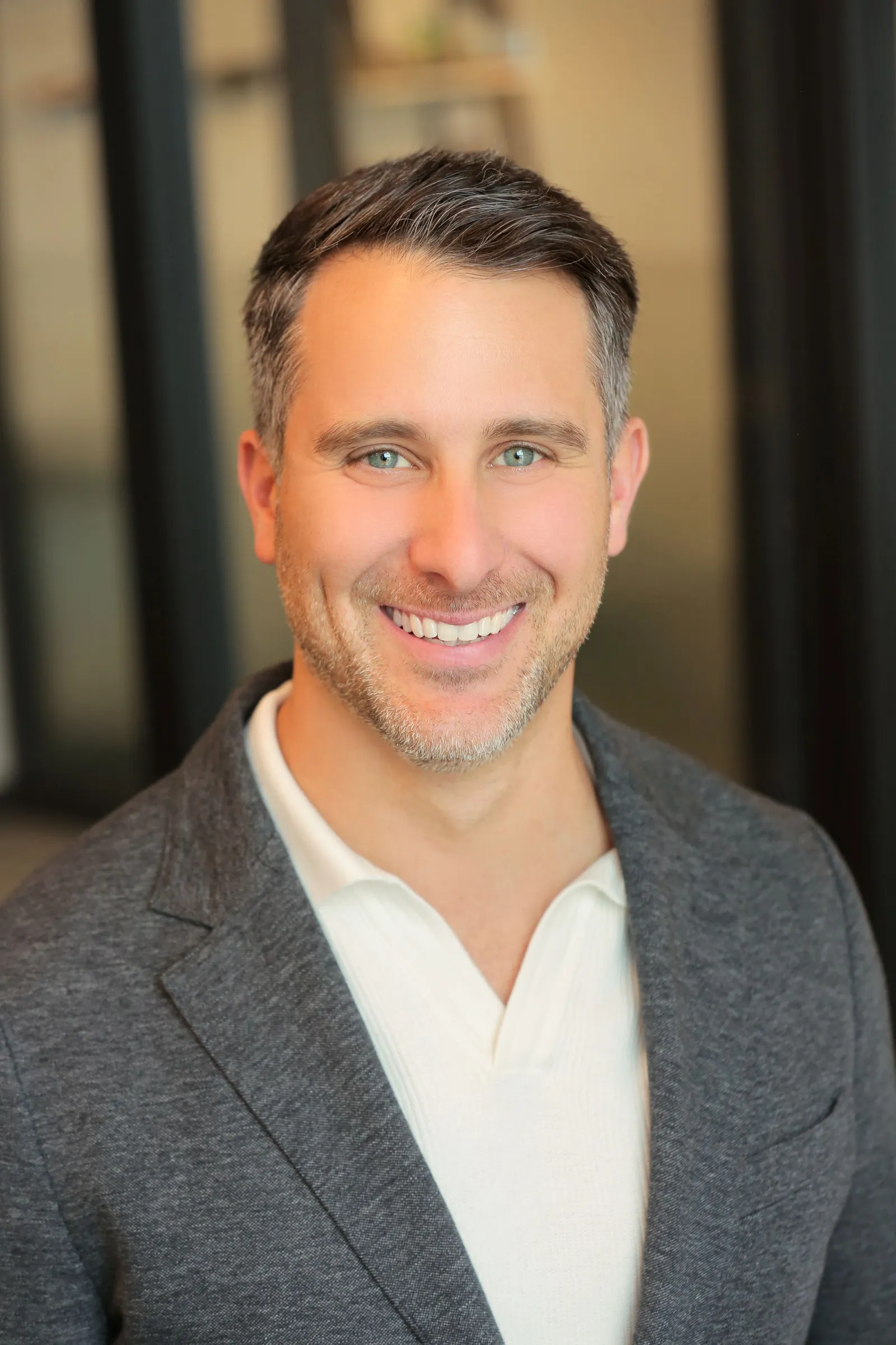 Headshot of man wearing blazer and polo