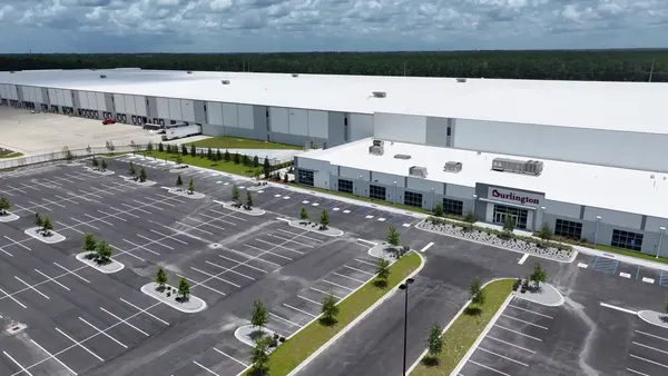An aerial view of a Burlington distribution center and an empty parking lot.