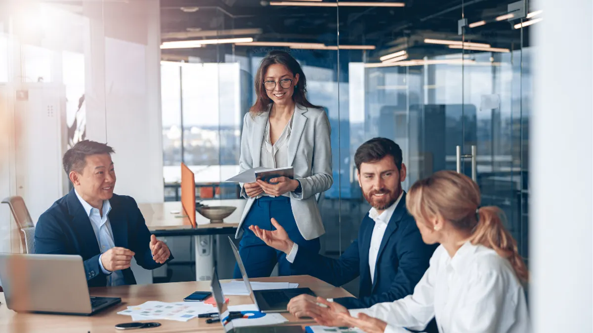 Employees in suit having a meeting in a conference room