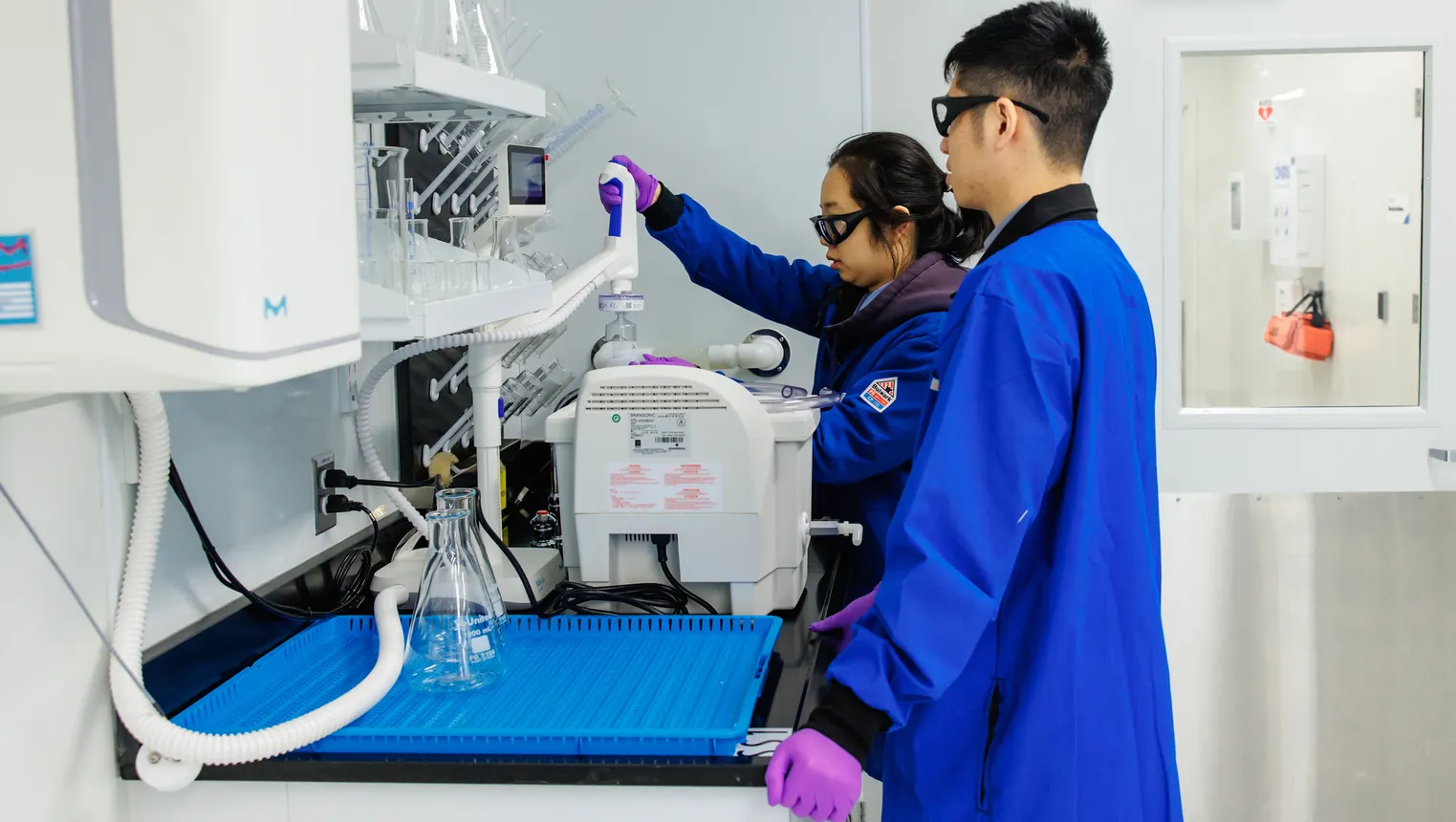 Two people in blue lab coats work in Braskem's Renewable Innovation Center in Lexington, Massachusetts