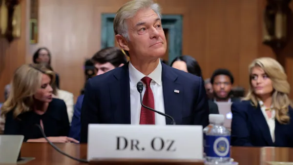 A picture of Mehemet Oz sitting behind a table in a Senate hearing room.