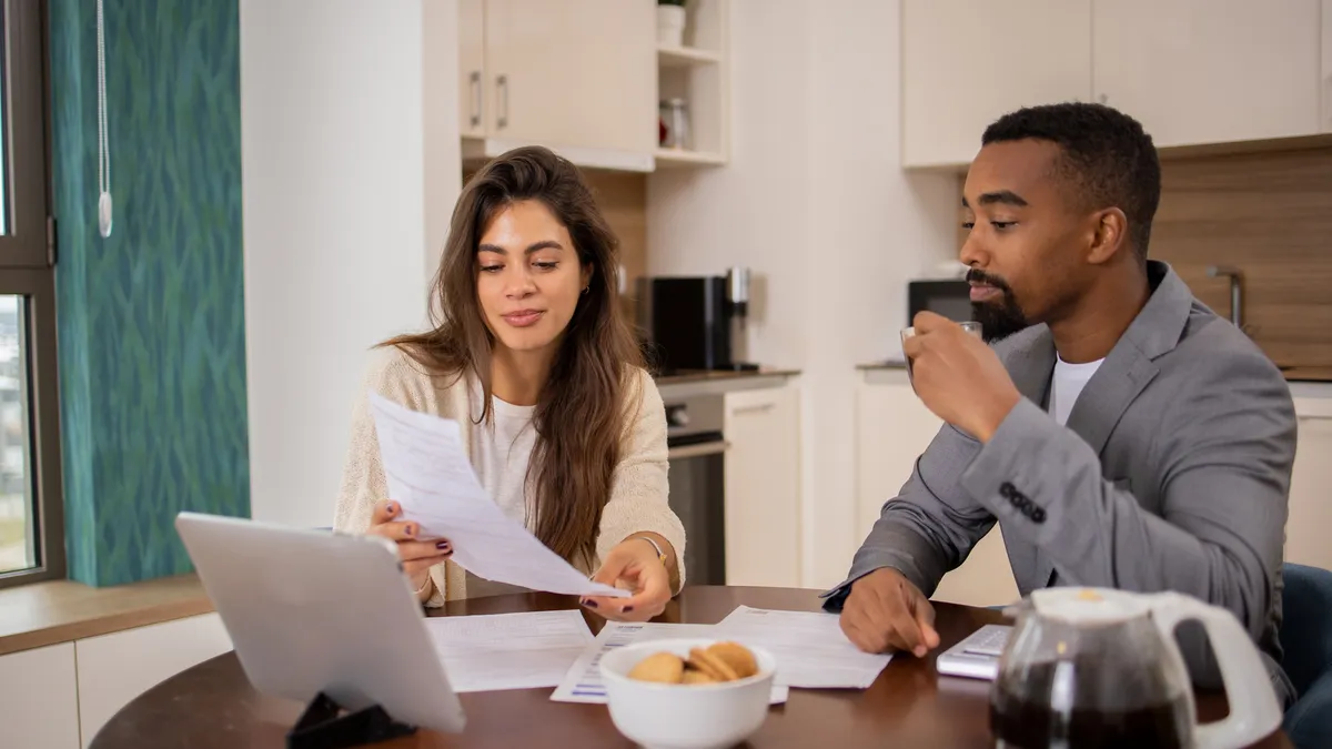 Two people sitting at table going over paperwork