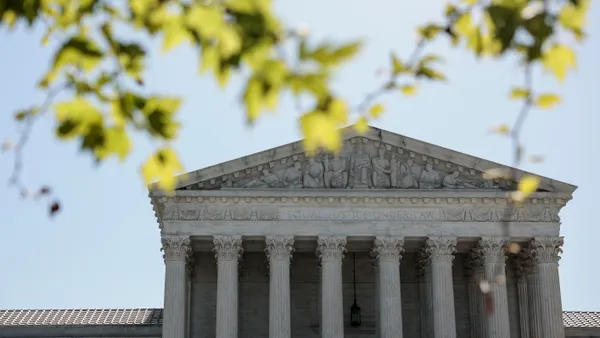 The U.S. Supreme Court is seen in spring through the branches of a tree.