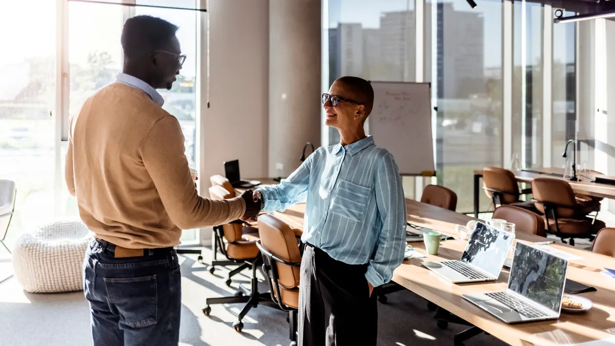 New employee shaking hands with manager.