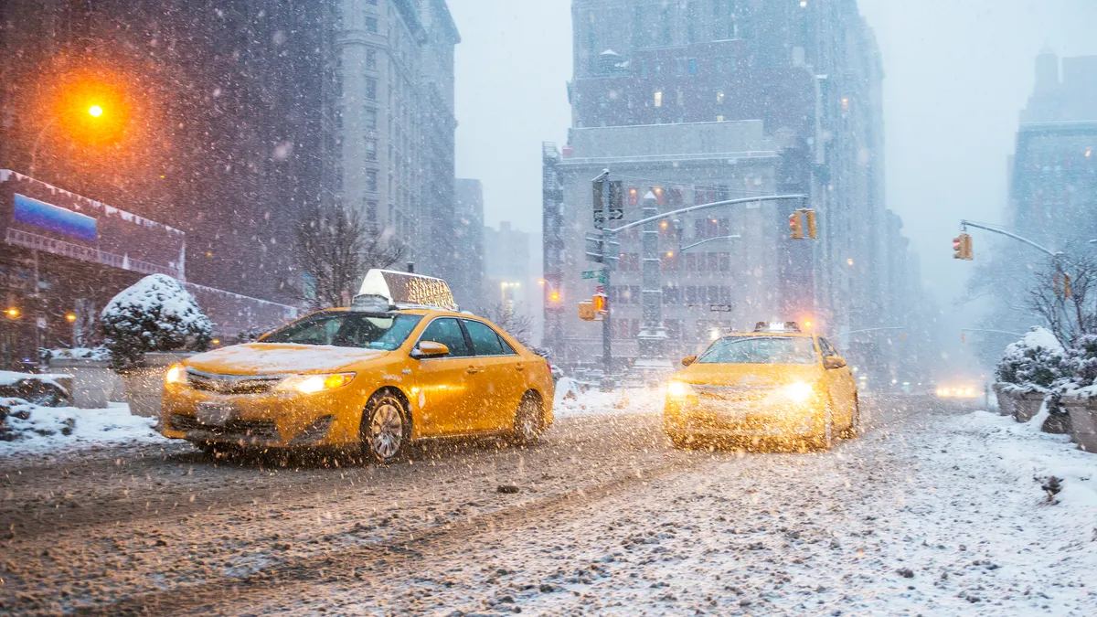 Taxis drive in heavy snow in New York City.