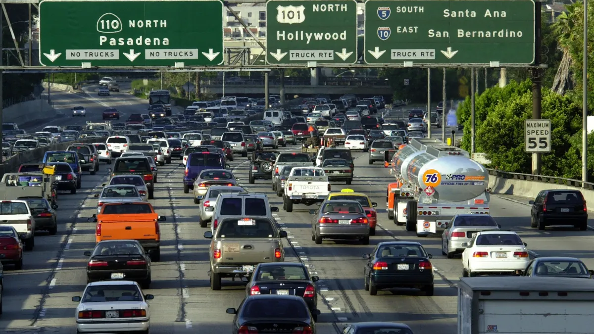 A view looking down on a multilane highway in Los Angeles with bumper-to-bumper traffic.