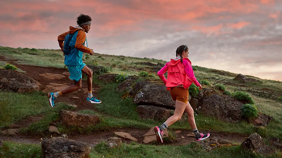 Two people running on a trail