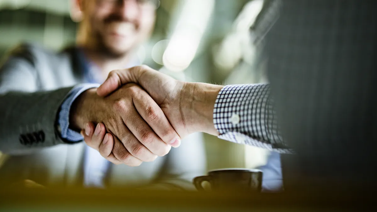 Two businessmen shake hands over a business deal.