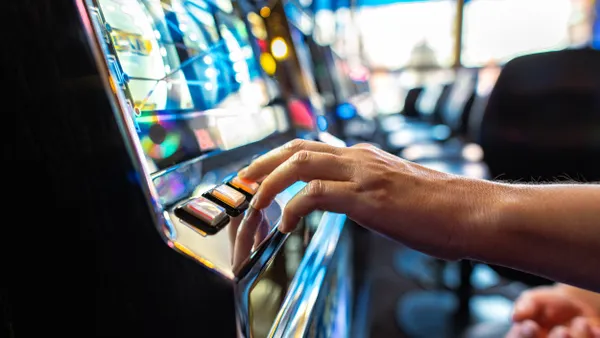 Close up of a hand playing slot machines