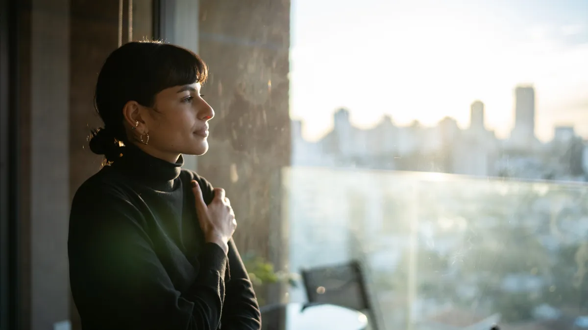 A woman contemplates life, while looking out of a window