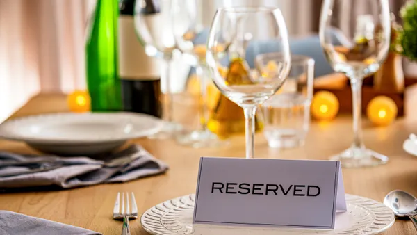 A sign on a table declaring it to be reserved.