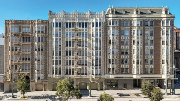 Three, tan mid-rise apartments