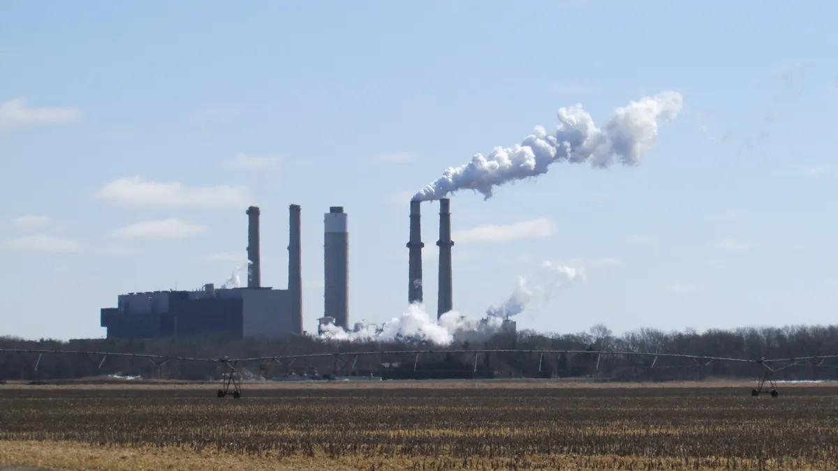 Smoke billows from the stacks of a power plant.
