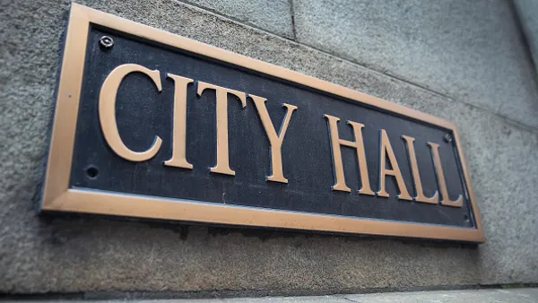 A bronze plaque seen on stone face of Chicago City Hall.