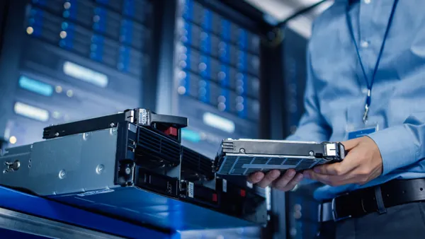 An IT professional prepares to install a hard drive in a business setting.