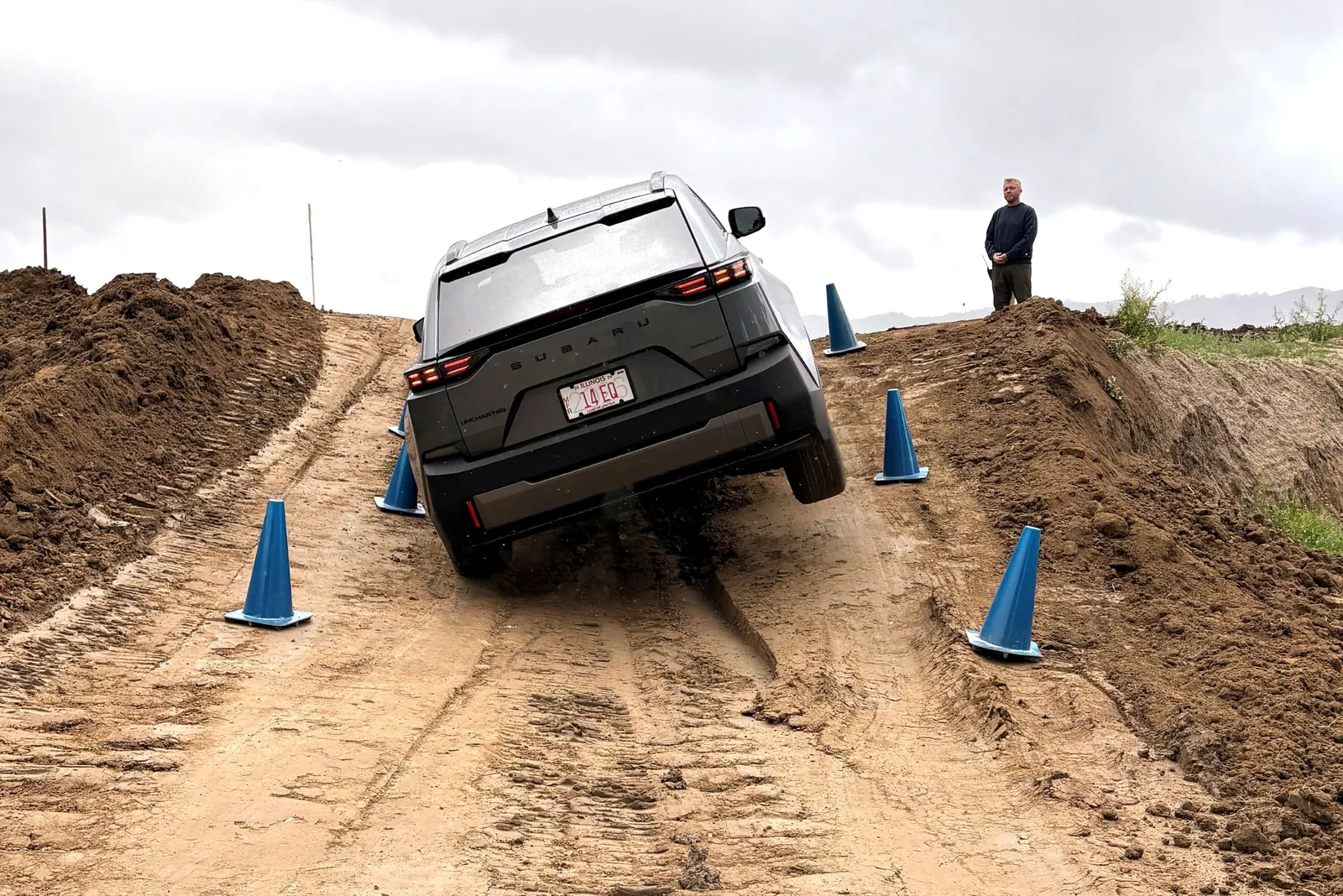 A 2026 Subaru Uncharted is driving, right-side wheels up, on a dirt off-road course in California.