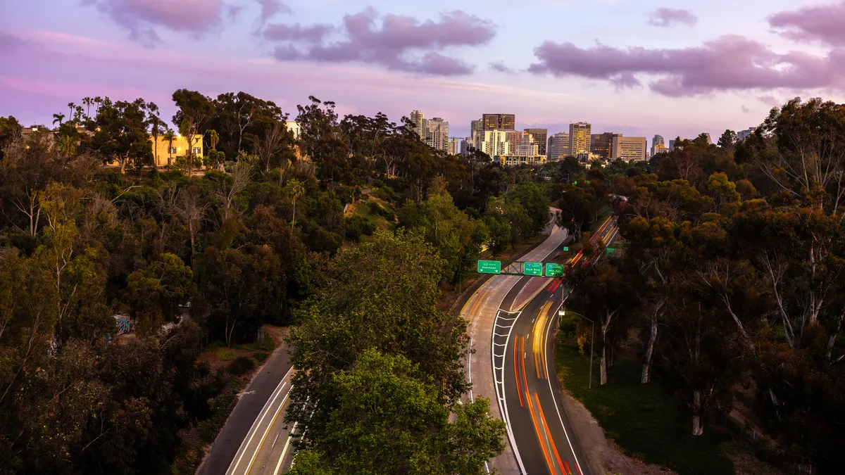 A photo with blurred traffic lights captures the motion of traffic along State Route 163 from Balboa Park in San Diego.