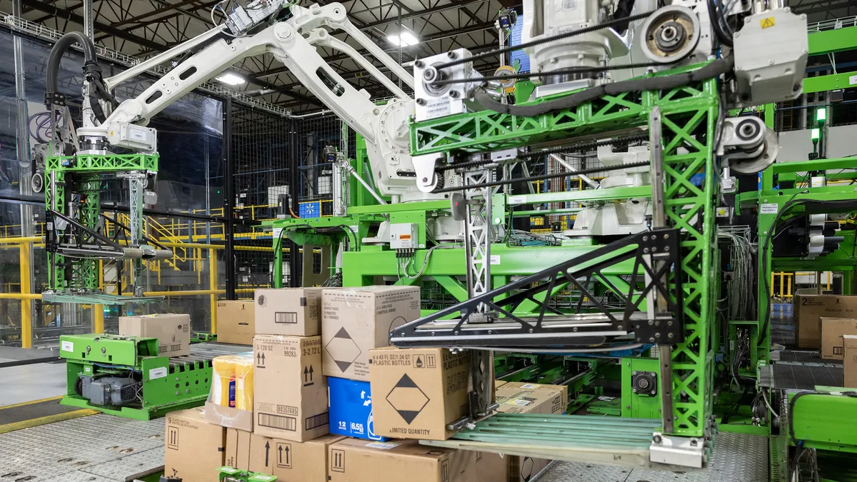 A neon green Symbotic robotic case-picking system building mixed-SKU pallets in a warehouse.