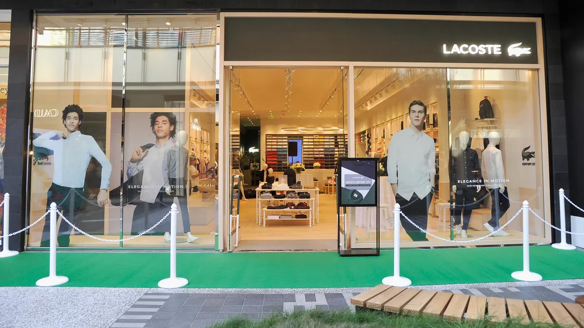 An exterior view of a Lacoste store featuring casual sportswear in the window.