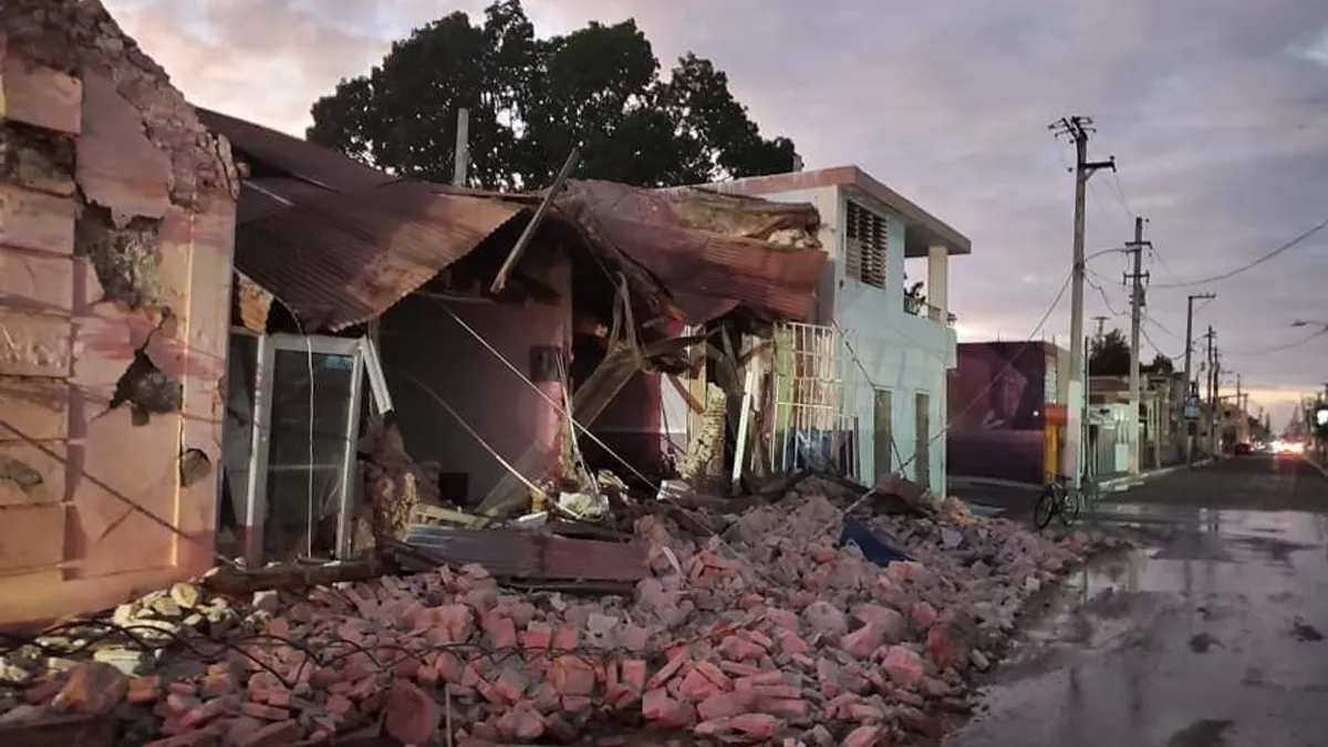 Guayanilla, Puerto Rico destruction in the wake of a 6.6 magnitude earthquake, showing a street with a fallen power line in the rubble.