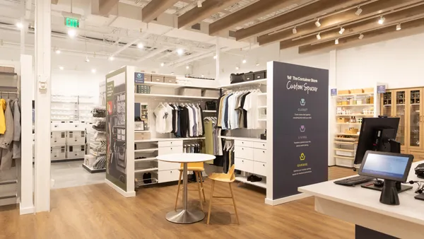 An organized closet display featuring The Container Store's "Custom Spaces" branding.