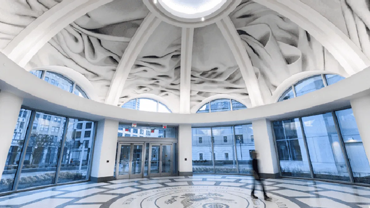 A circular rotunda under a dome with a mosaic floor and windows on all sides.