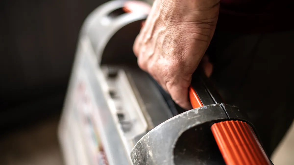 A person holds a toolbox.