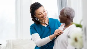 Healthcare professional using stethoscope to examine senior patient's chest