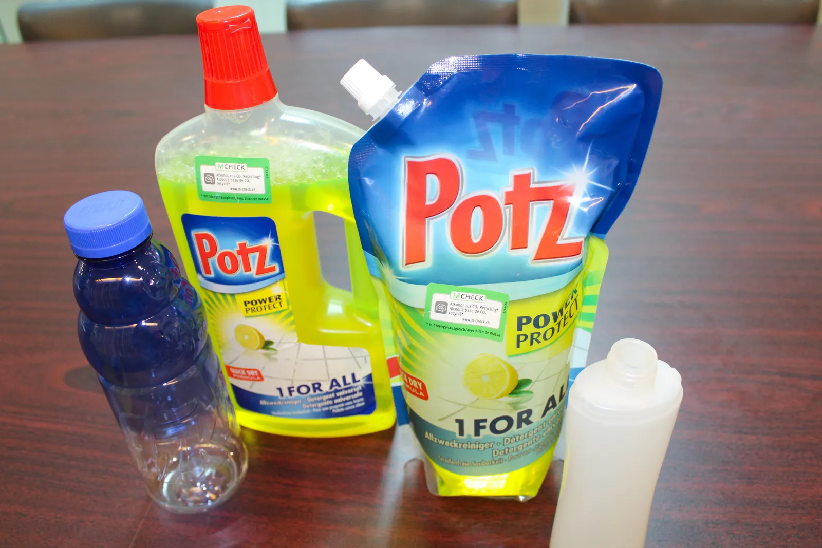 A plastic water bottle, two plastic bottles with household cleaner, and a plastic shampoo bottle.