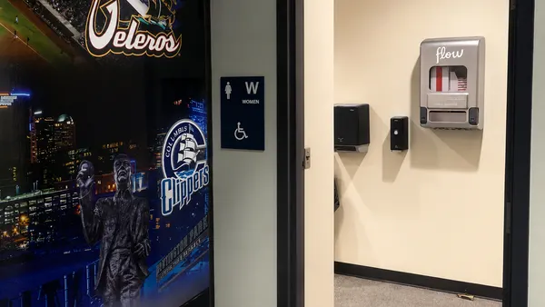 The entrance to a women's bathroom with an Aunt Flow period product dispenser inside.