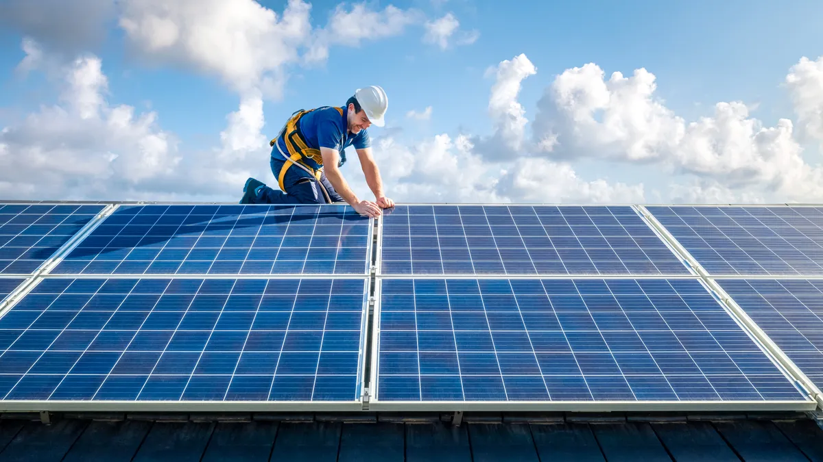 Professional worker installing solar panels on the roof of a house